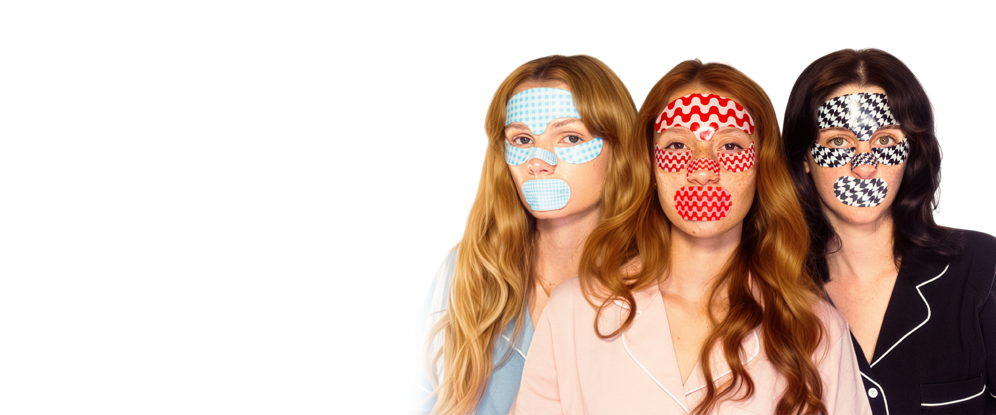 Three women wearing patterned eye masks on a white background