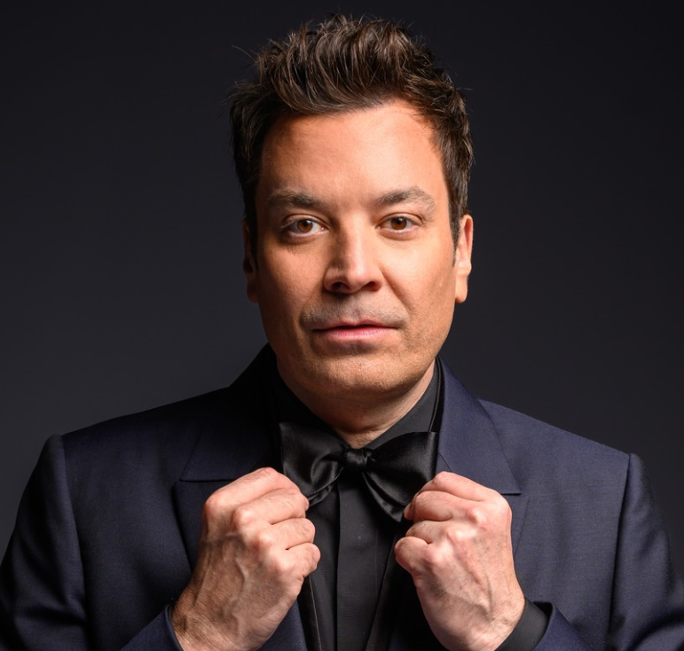 Jimmy Fallon wearing a suit in a blue background